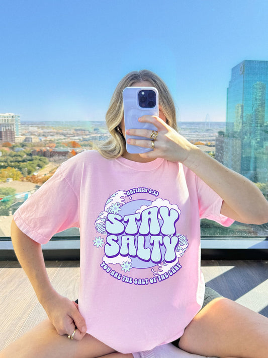 T-shirt with purple and mint green 'Stay Salty' text design featuring Matthew 5:13 scripture and retro styling