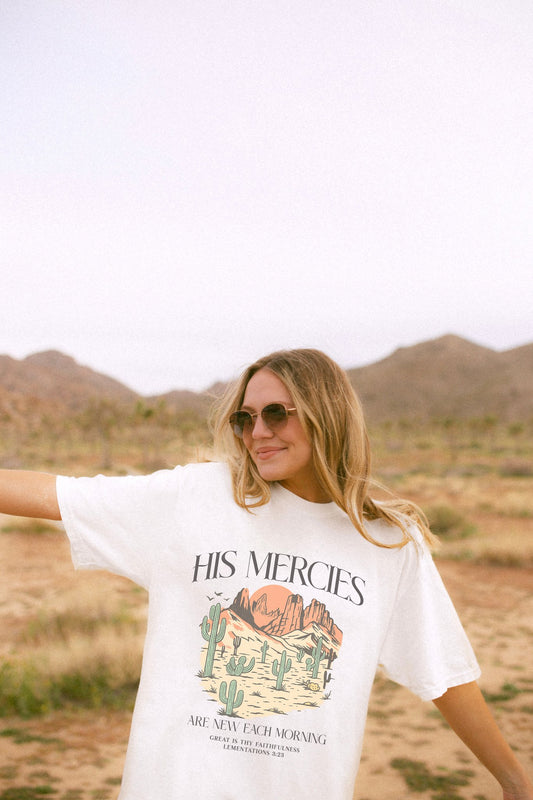 T-shirt with desert landscape design featuring cacti, mountains, and 'His Mercies Are New Each Morning' text with Lamentations 3:23 bible verse