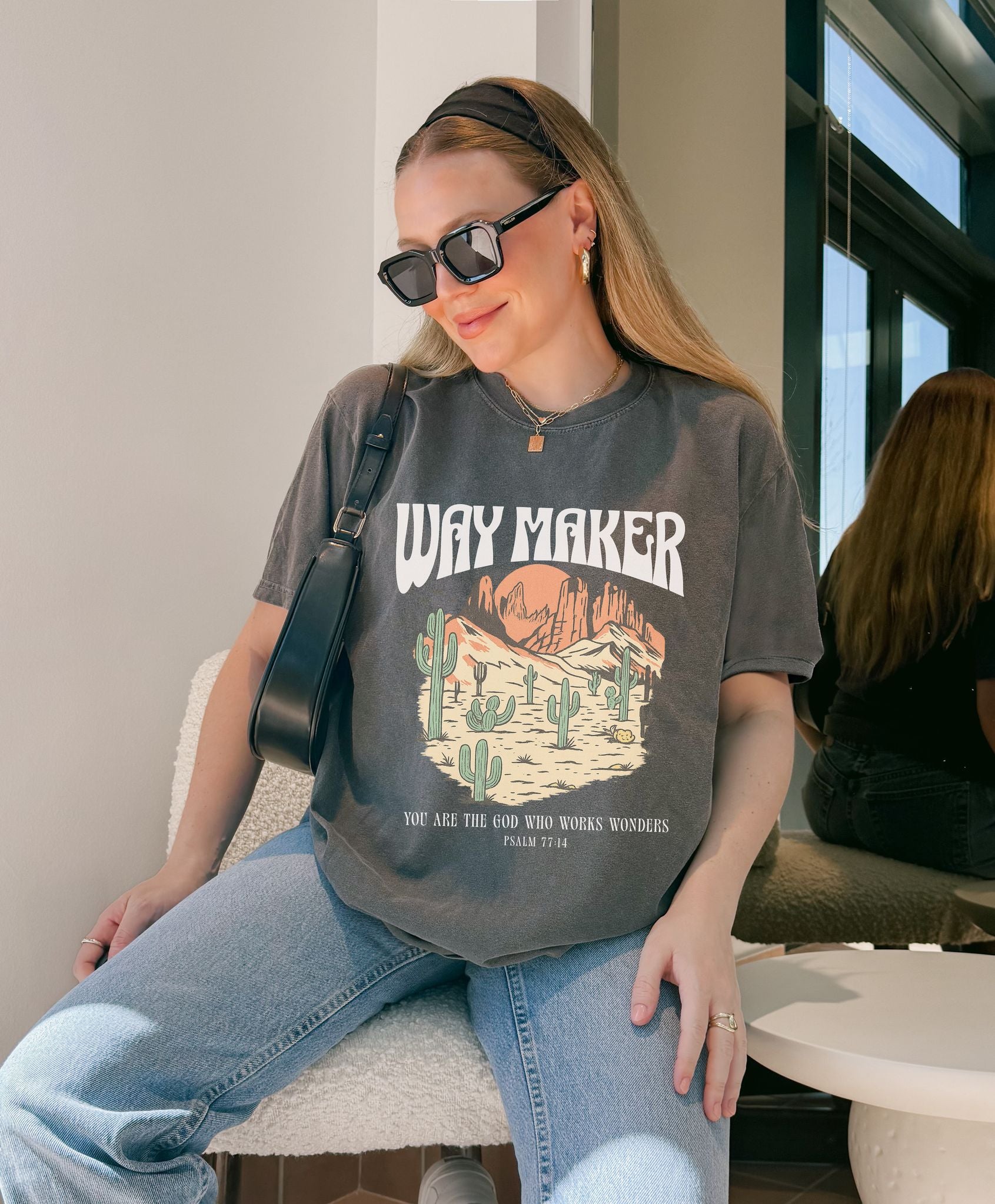 T-shirt with Way Maker text, desert landscape featuring cacti, mountains, and orange sunset with Psalm 77:14 verse