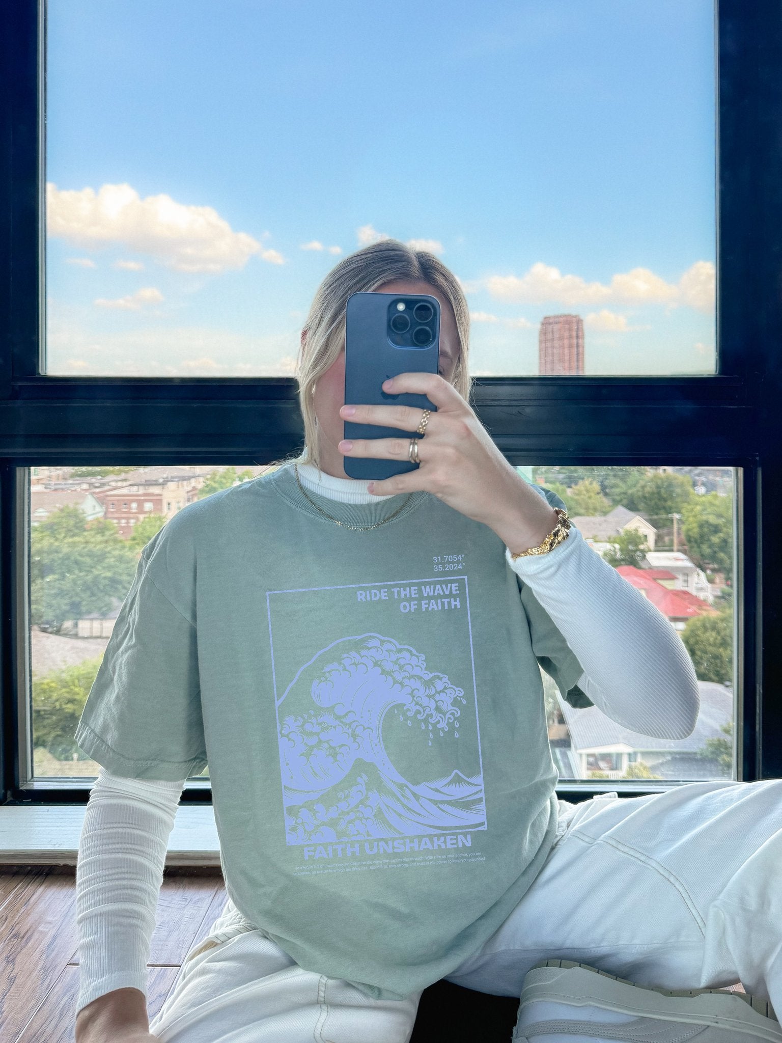 T-shirt with blue ocean wave design featuring 'Ride The Wave Of Faith' and 'Faith Unshaken' text