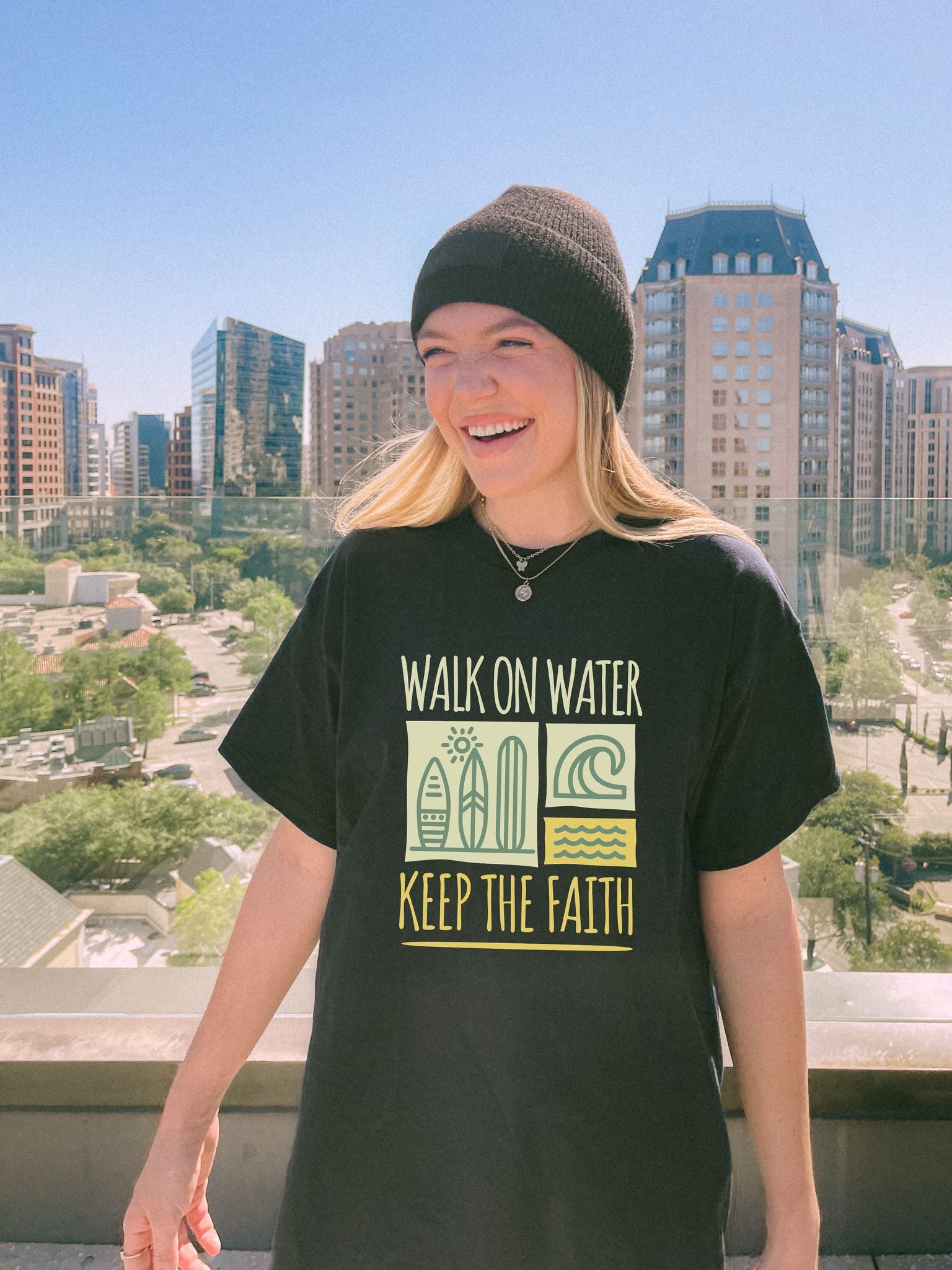 T-shirt with yellow Walk On Water Keep The Faith text, retro surfboard graphics and teal wave designs