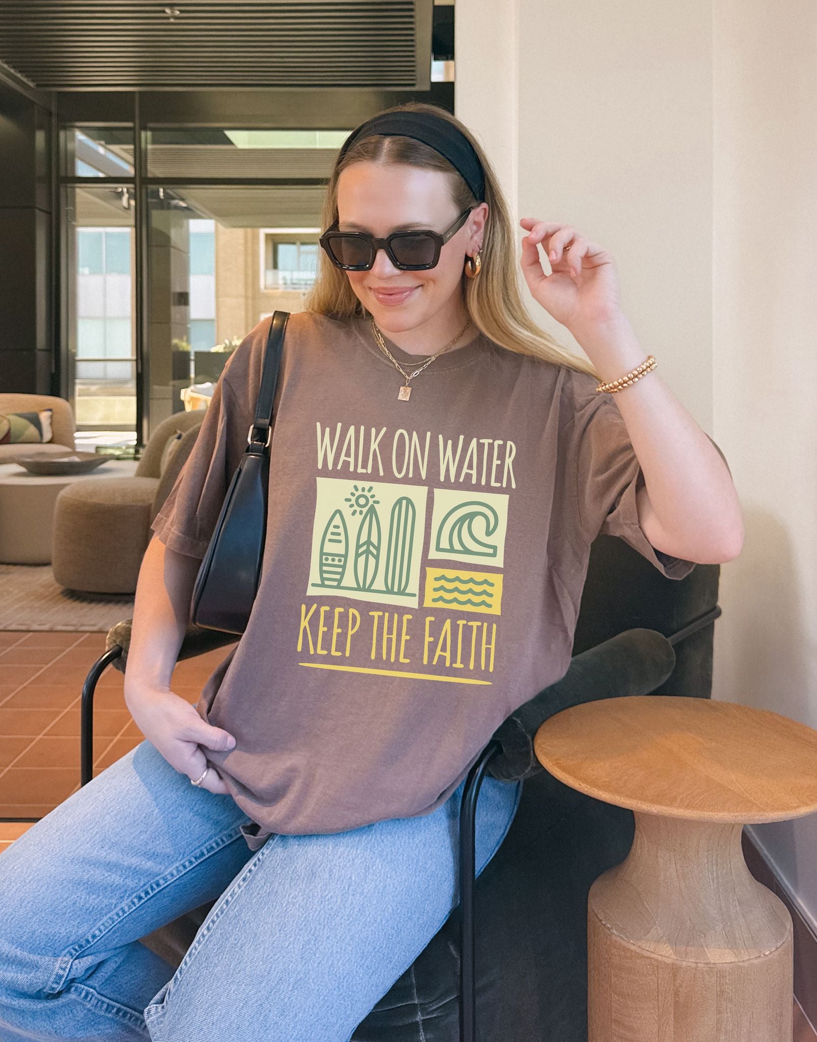 T-shirt with yellow Walk On Water Keep The Faith text, retro surfboard graphics and teal wave designs