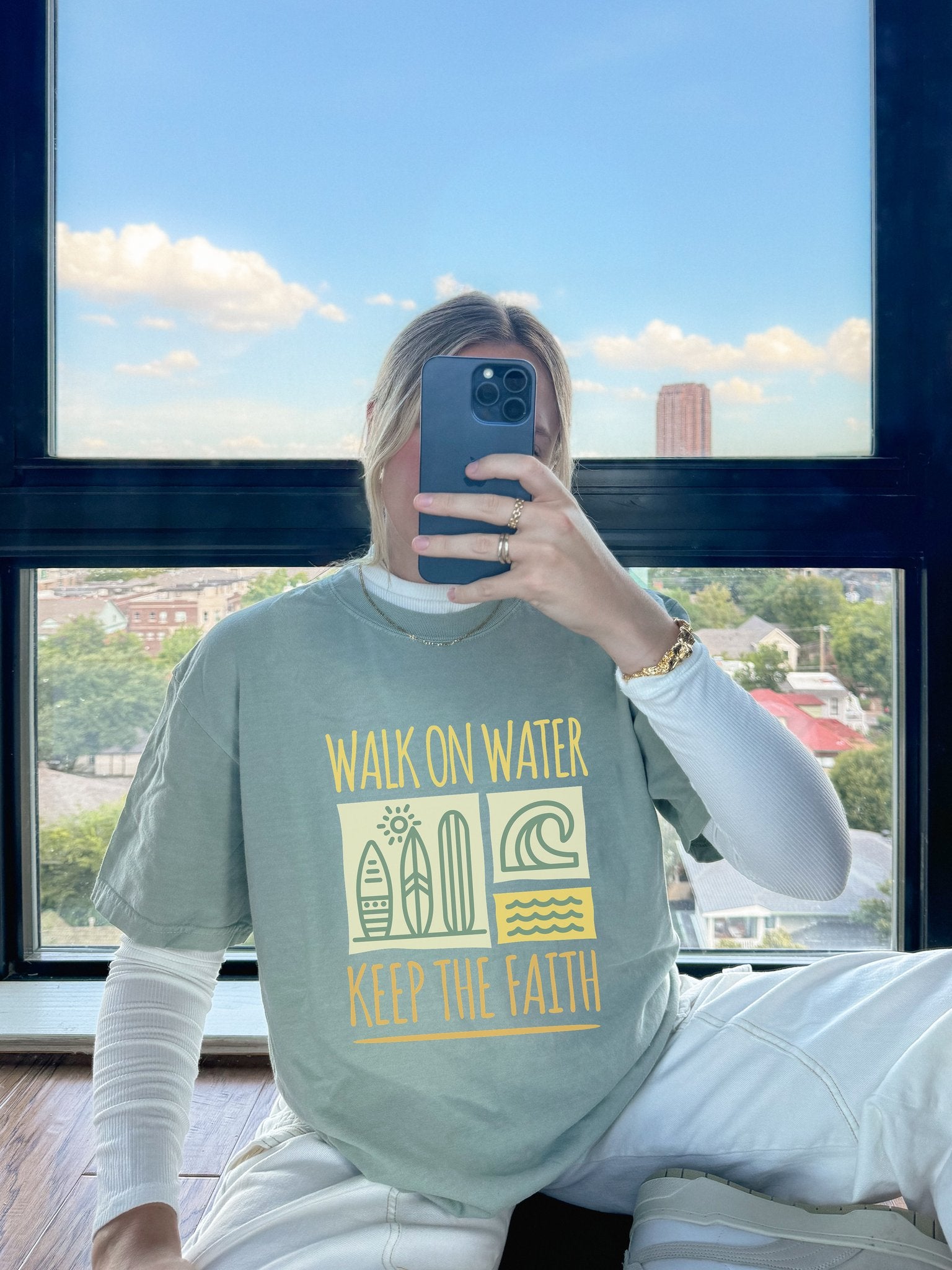 T-shirt with yellow Walk On Water Keep The Faith text, retro surfboard graphics and teal wave designs