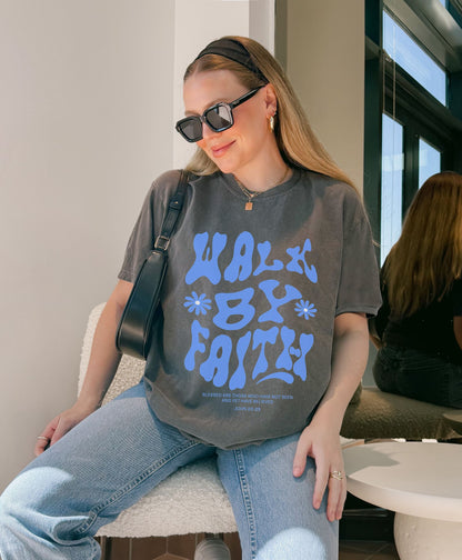 T-shirt with retro wavy font reading 'Walk By Faith' in blue letters with flower accents and John 20:29 scripture