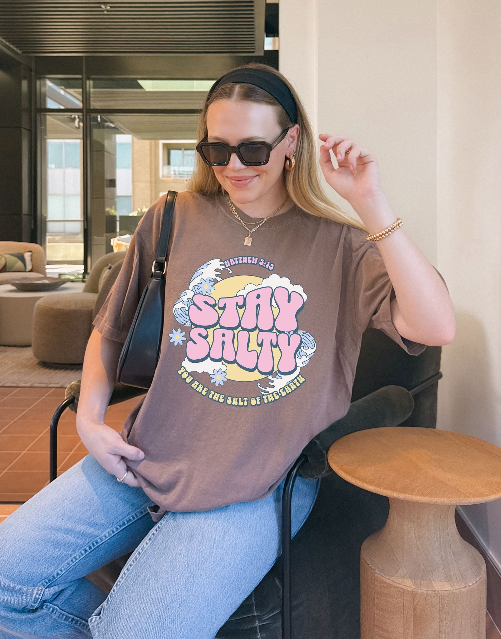 Christian t-shirt with pink 'Stay Salty' text, Matthew 5:13 verse, ocean waves and daisy flowers