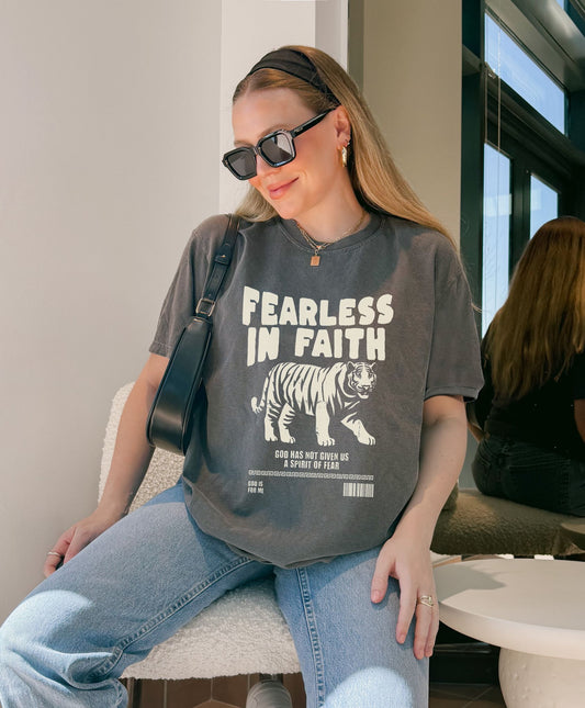 A t-shirt featuring 'Fearless In Faith' text design in elegant cream colored typography