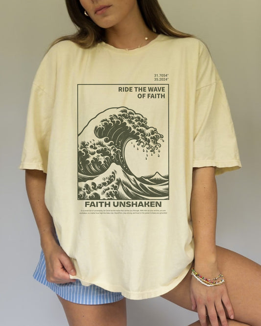 T-shirt with ocean wave design featuring 'Ride The Wave of Faith' and 'Faith Unshaken' text