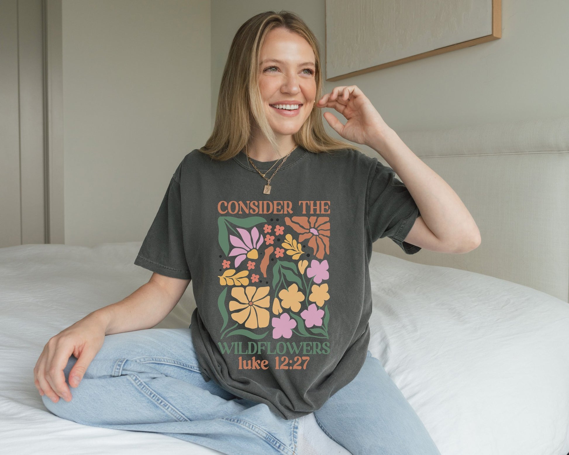T-shirt with colorful wildflower design and 'Consider the Wildflowers Luke 12:27' bible verse text