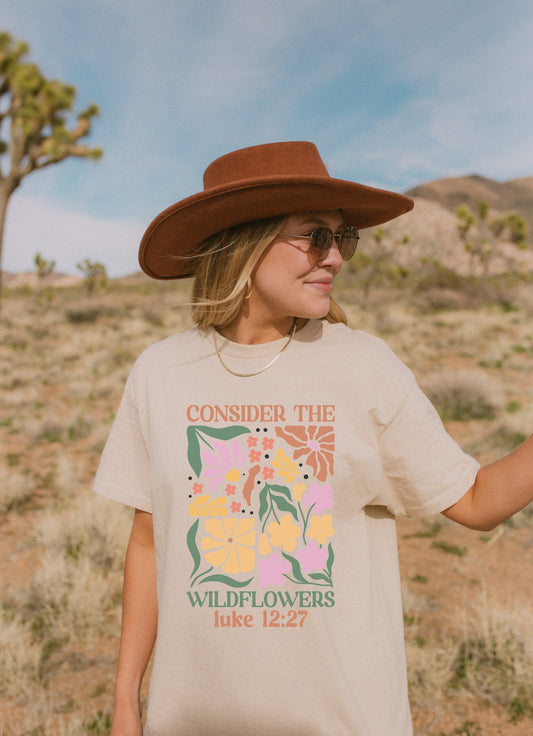 T-shirt with colorful wildflower design and 'Consider the Wildflowers Luke 12:27' bible verse text