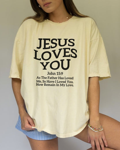Black text design on t-shirt reading Jesus Loves You with John 15:9 Bible verse