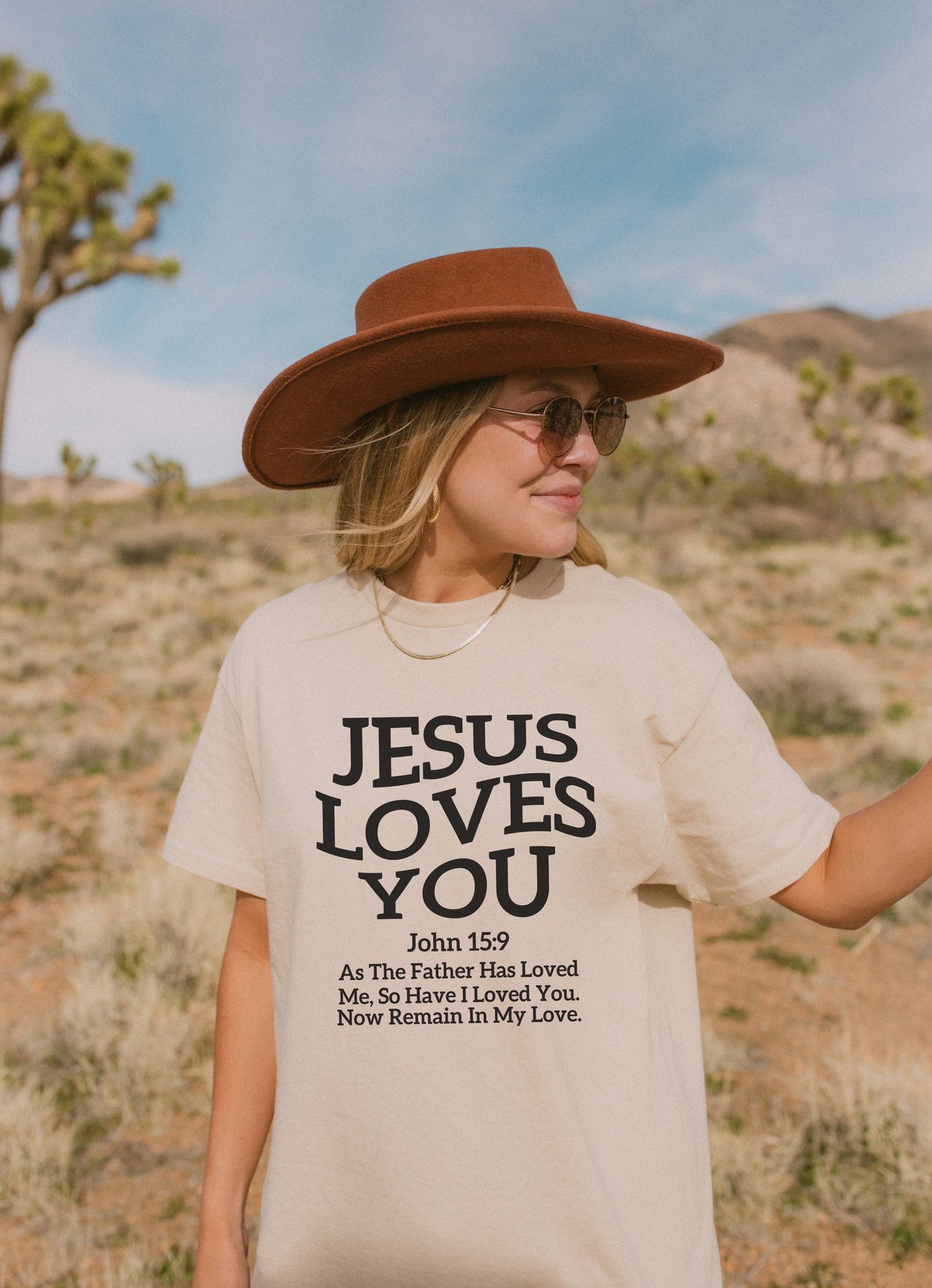 Black text design on t-shirt reading Jesus Loves You with John 15:9 Bible verse