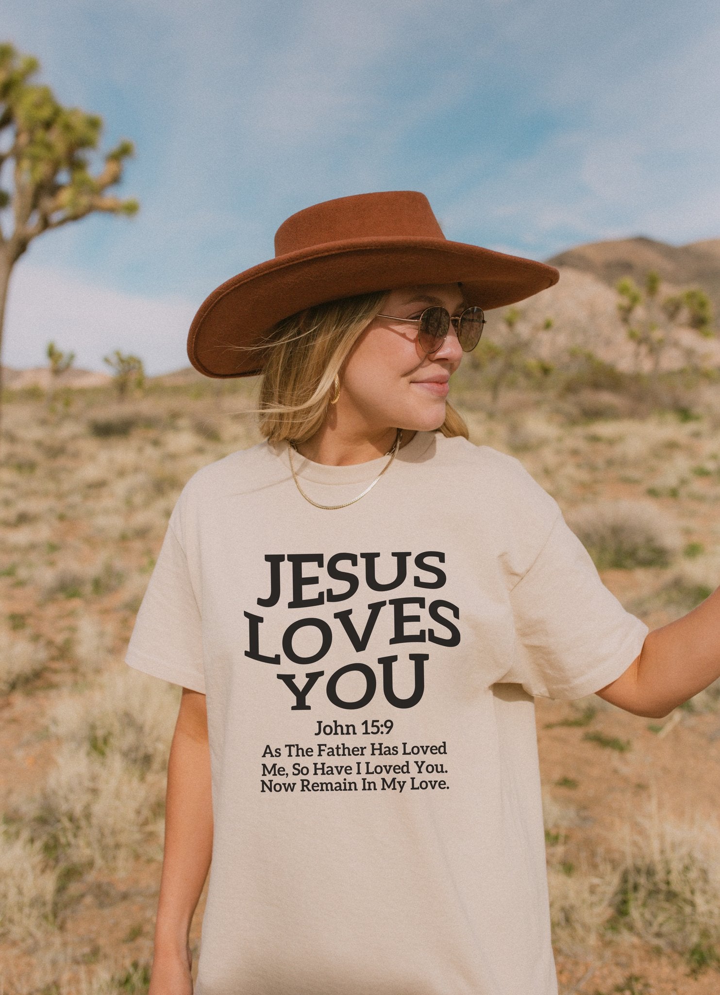 Black text design on t-shirt reading Jesus Loves You with John 15:9 Bible verse