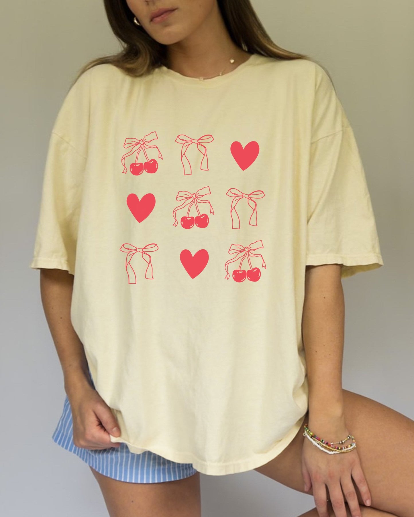 T-shirt with red cherry and bow pattern featuring hearts and ribbon bow designs