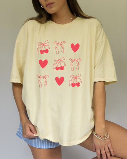 T-shirt with red cherry and bow pattern featuring hearts and ribbon bow designs