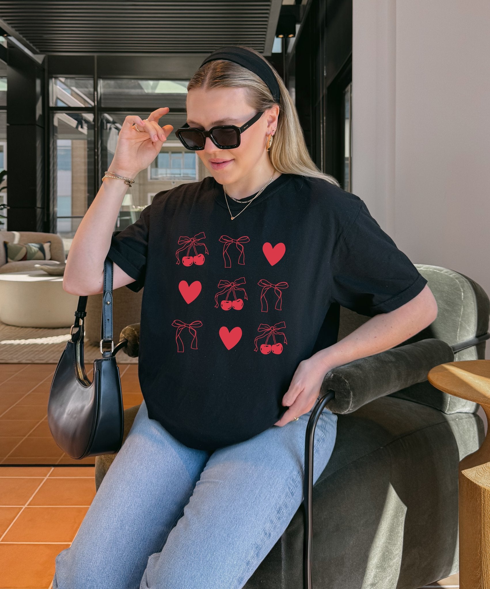 T-shirt with red cherry and bow pattern featuring hearts and ribbon bow designs