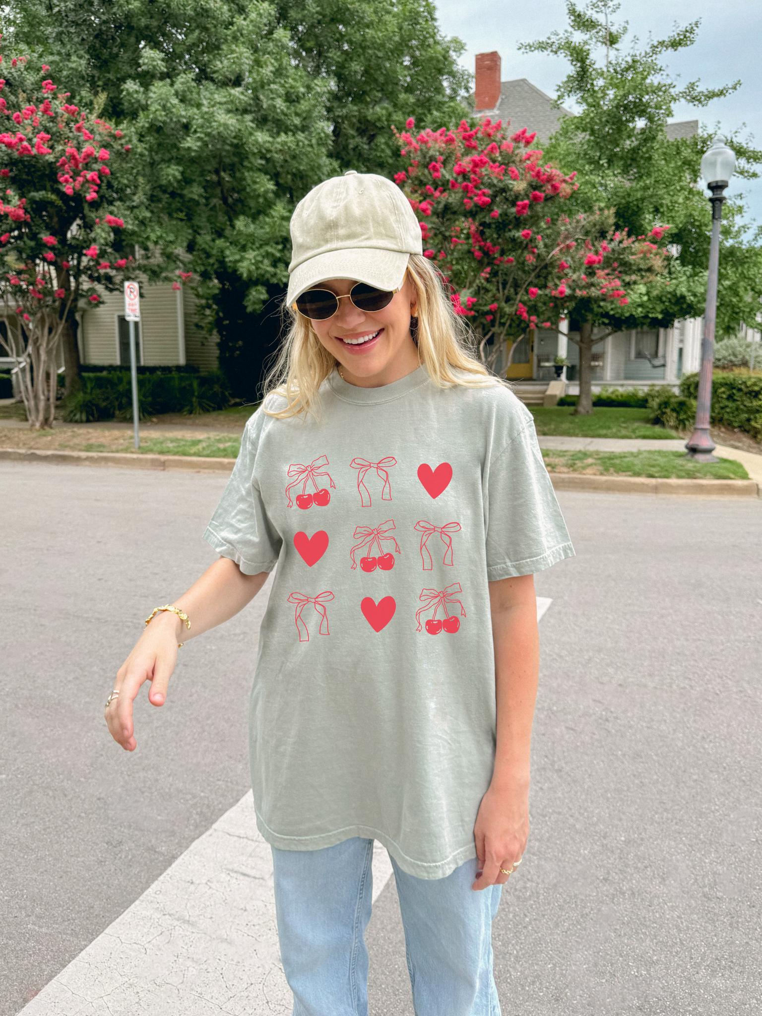 T-shirt with red cherry and bow pattern featuring hearts and ribbon bow designs