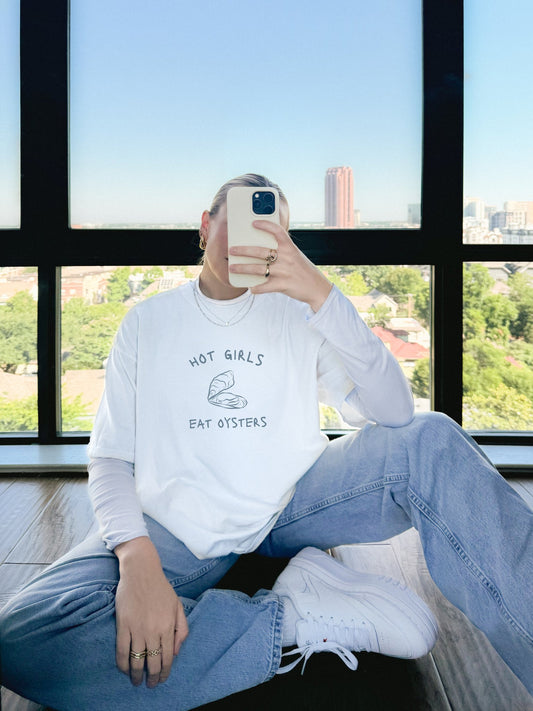 T-shirt with 'Hot Girls Eat Oysters' text and minimalist oyster shell illustration in blue tones