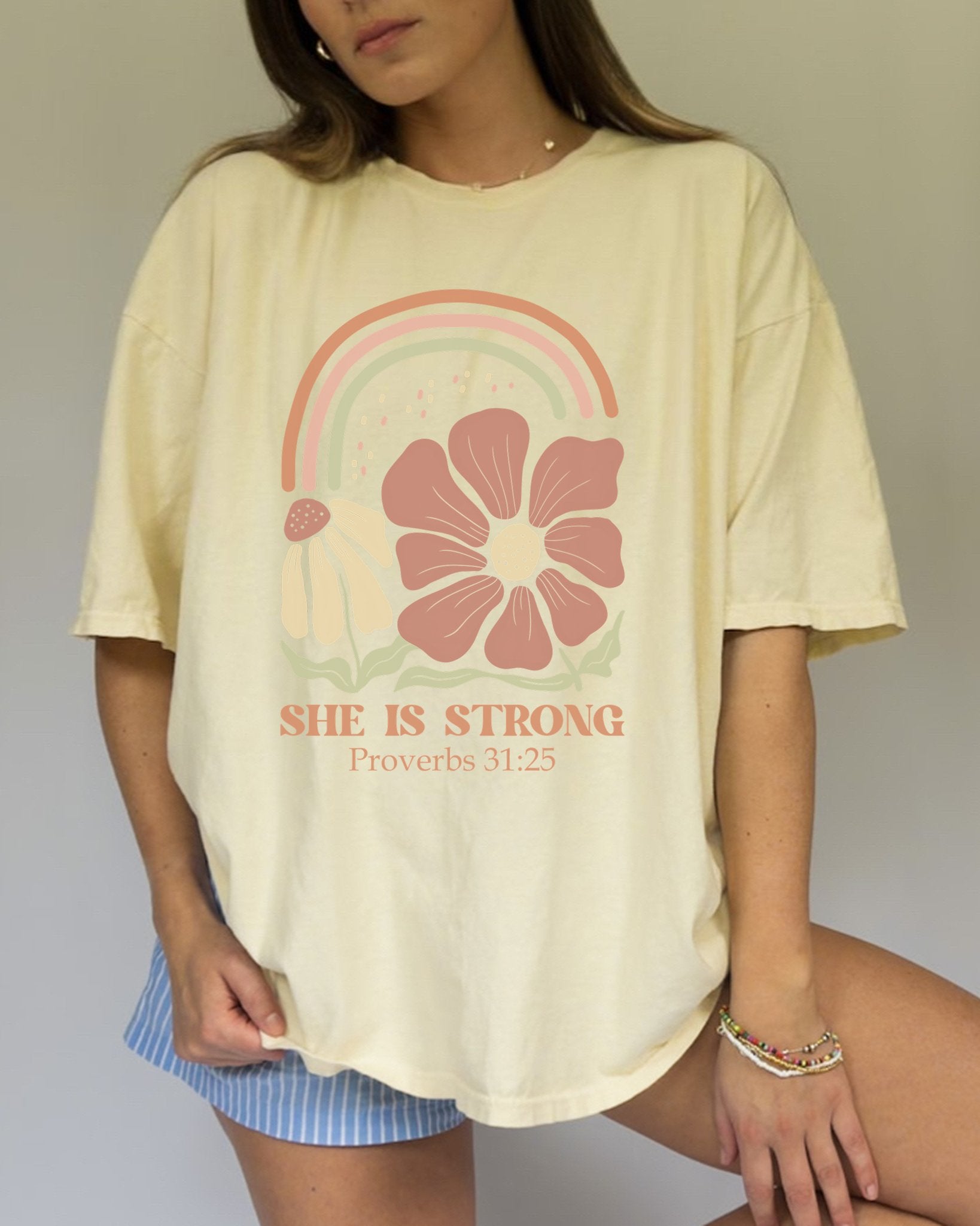 T-shirt with boho rainbow, terracotta and cream flowers, and 'She Is Strong Proverbs 31:25' text