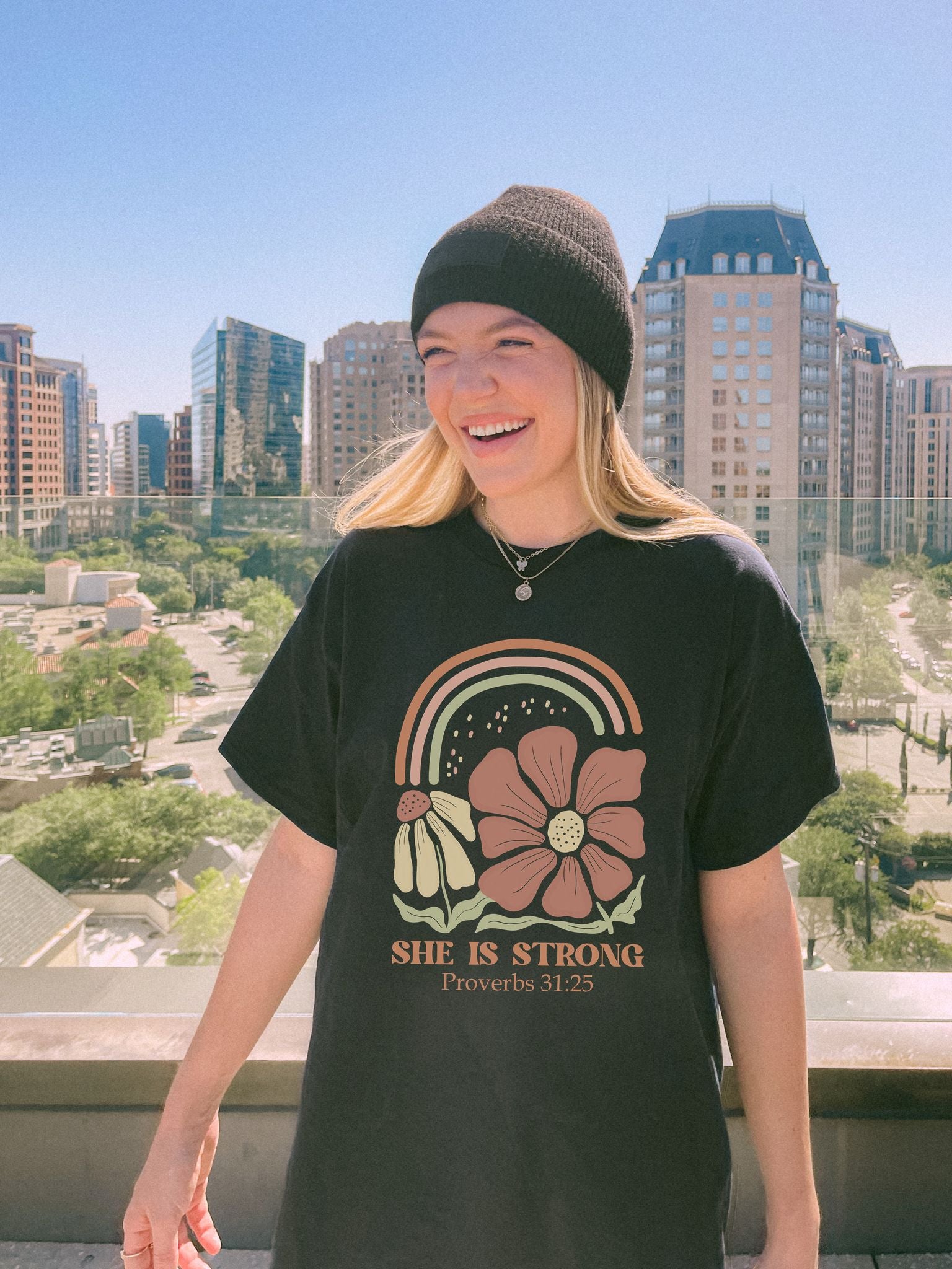 T-shirt with boho rainbow, terracotta and cream flowers, and 'She Is Strong Proverbs 31:25' text
