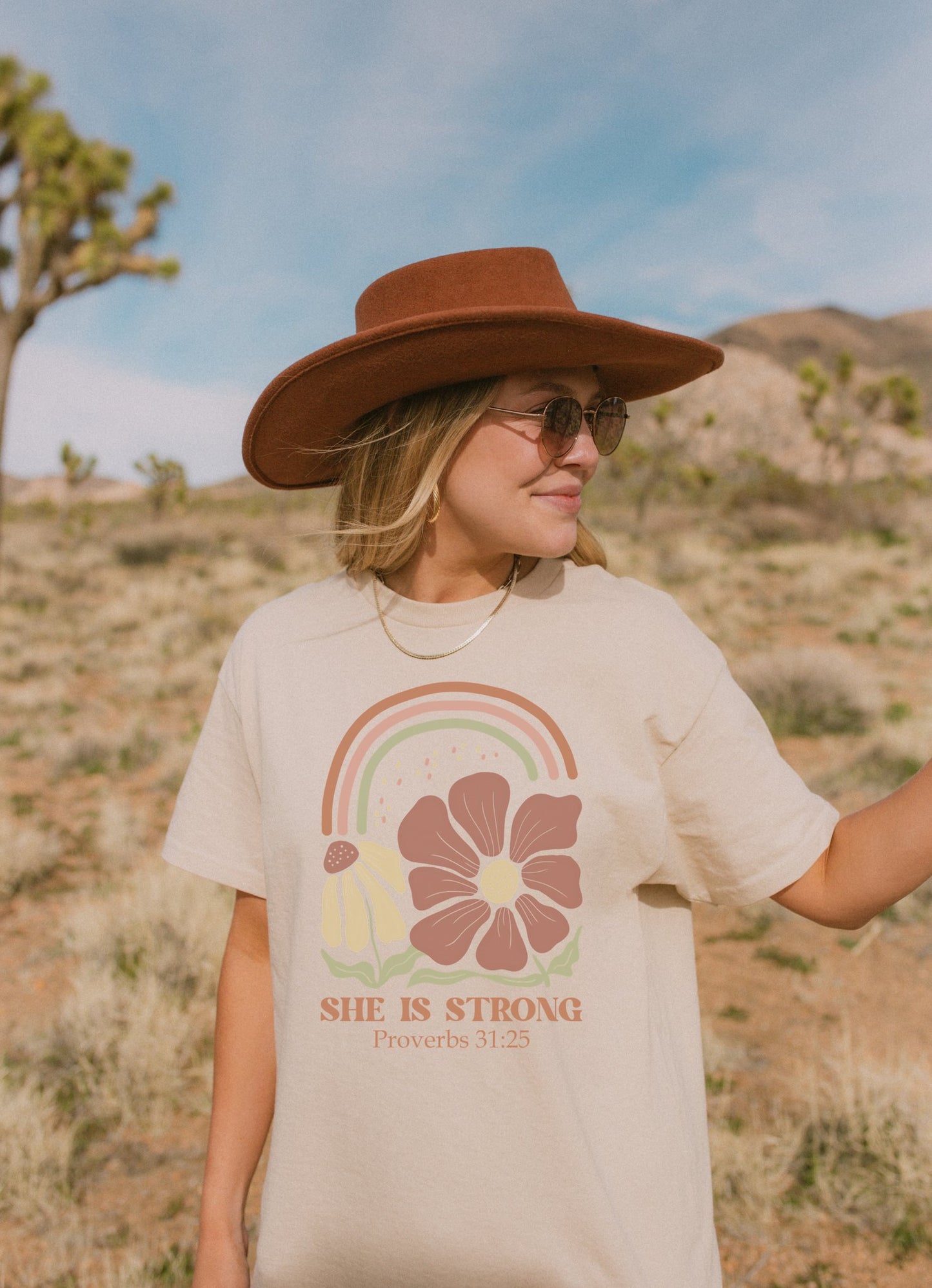 T-shirt with boho rainbow, terracotta and cream flowers, and 'She Is Strong Proverbs 31:25' text