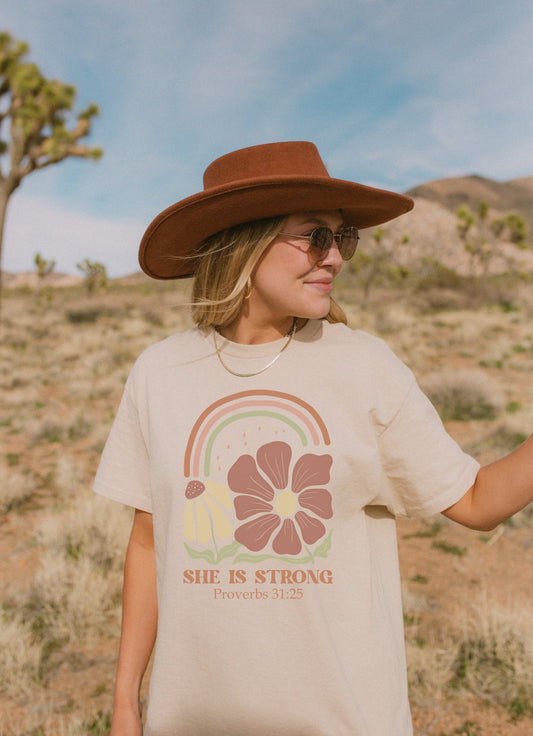 T-shirt with boho rainbow, terracotta and cream flowers, and 'She Is Strong Proverbs 31:25' text
