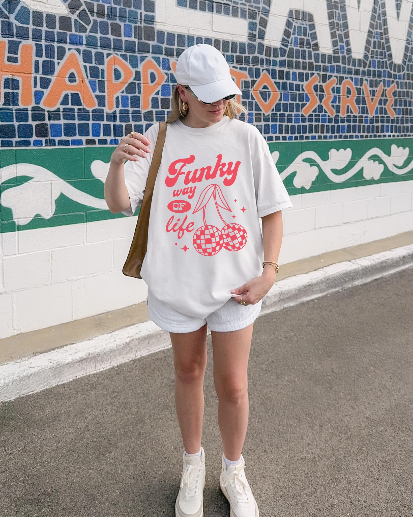 T-shirt with red retro cherry design featuring checkered disco ball cherries and funky typography
