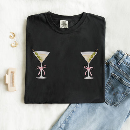 T-shirt design with two martini glasses containing olives and pink bow details creating a humorous cocktail theme