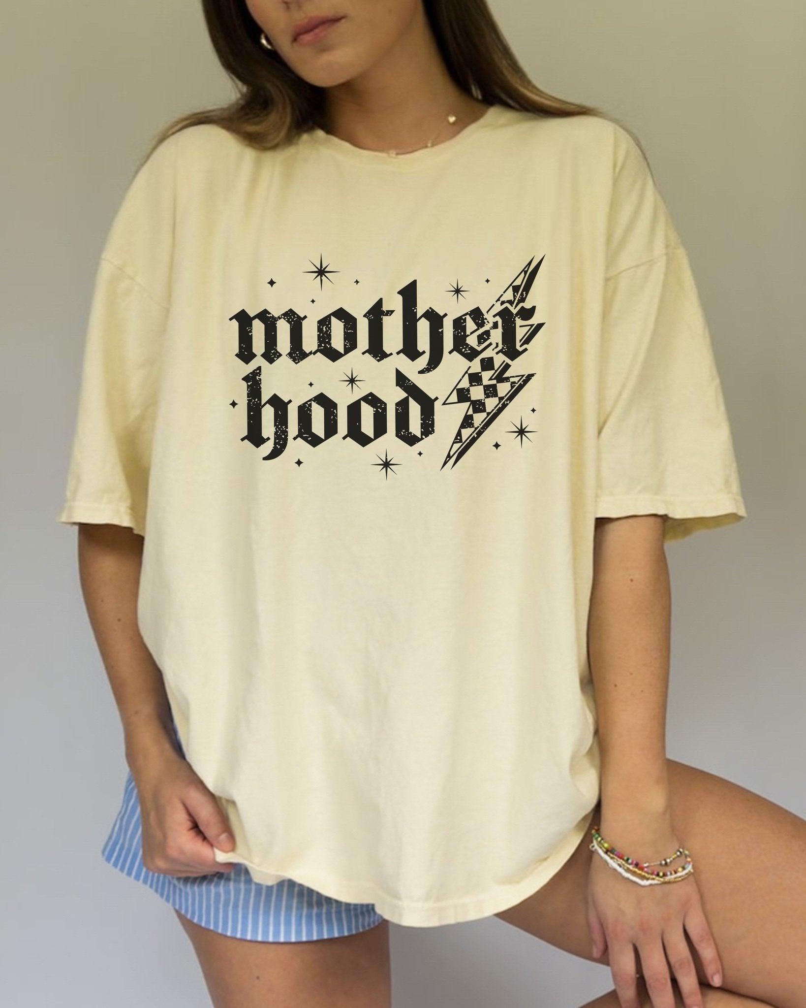 T-shirt with gothic Mother Hood text, lightning bolt graphics, and checkerboard pattern elements