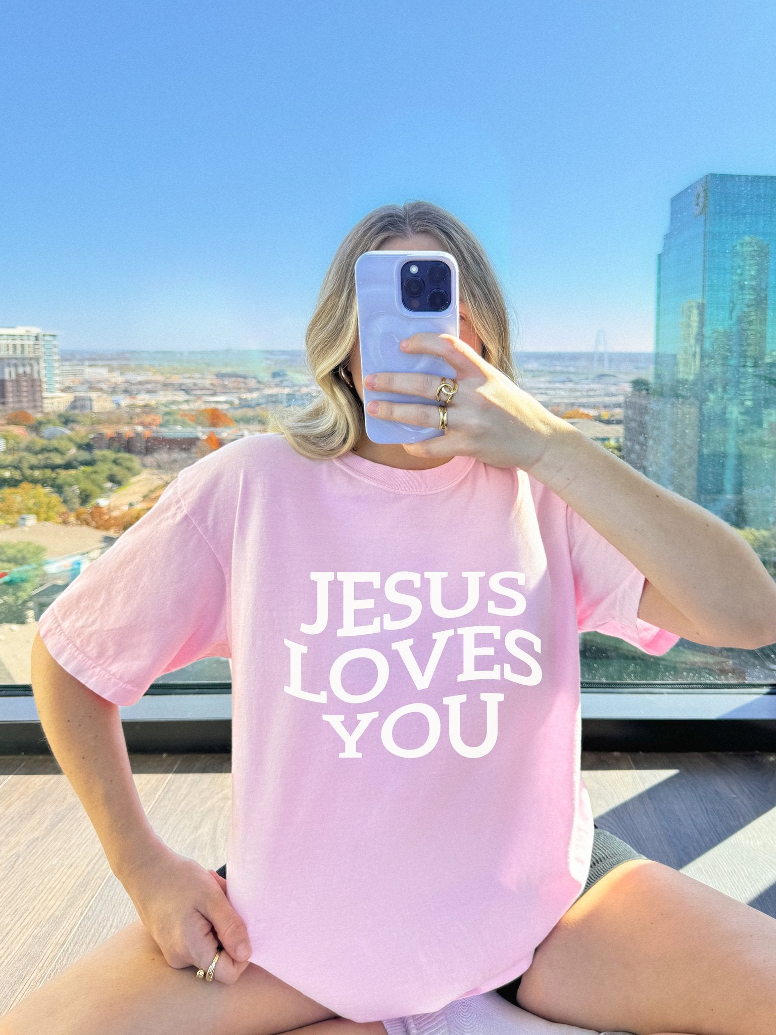 T-shirt with bold black text reading 'JESUS LOVES YOU' in large serif typography