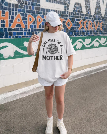 Black and white t-shirt with roaring tiger head and 'One Hell Of A Mother' text in distressed lettering