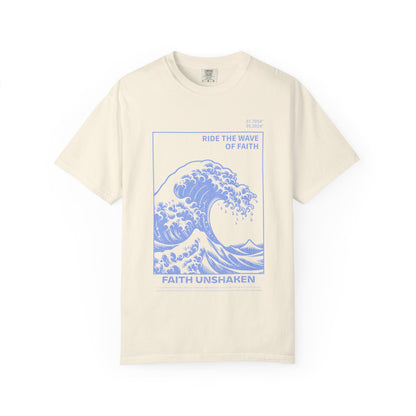 T-shirt with blue ocean wave design featuring 'Ride The Wave Of Faith' and 'Faith Unshaken' text
