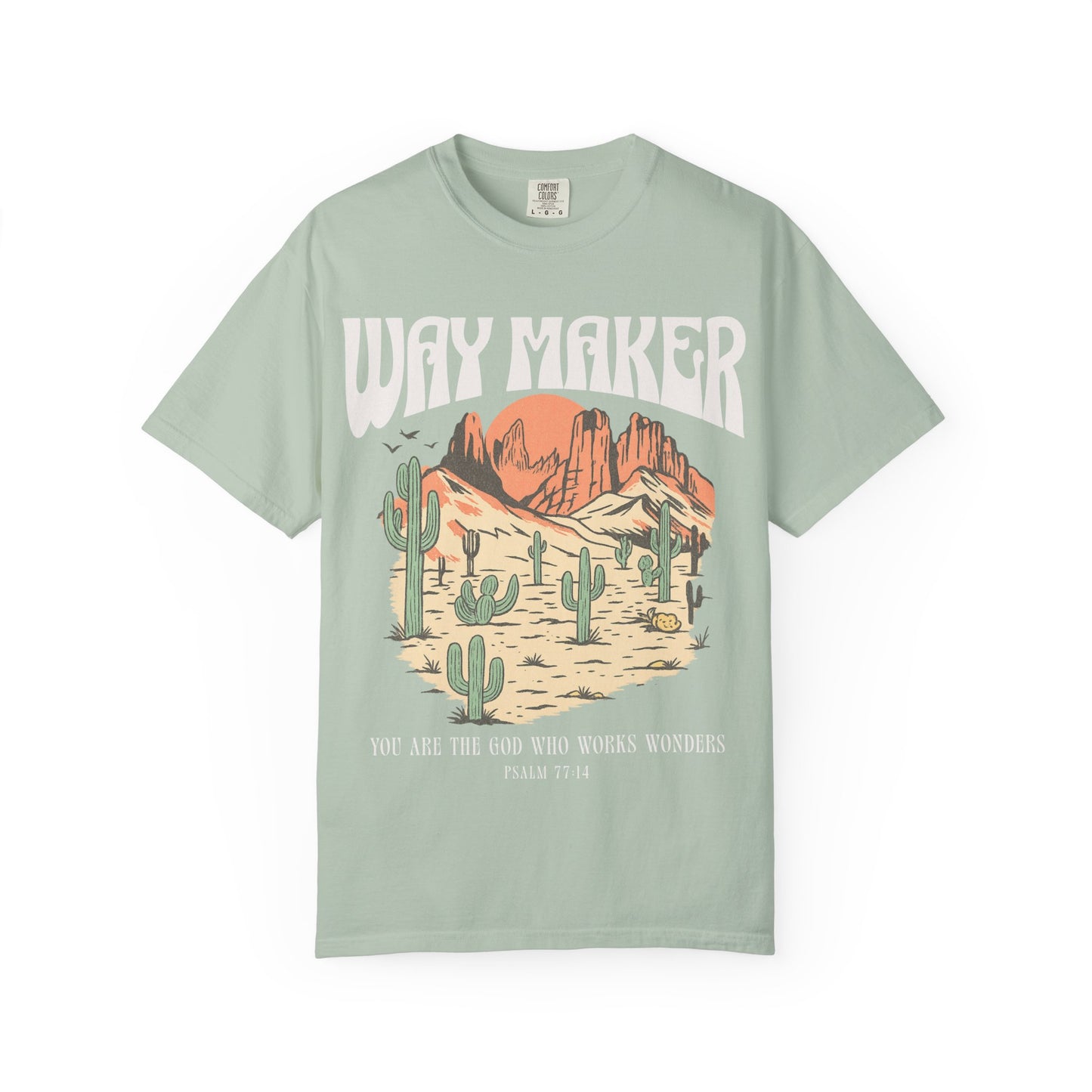 T-shirt with Way Maker text, desert landscape featuring cacti, mountains, and orange sunset with Psalm 77:14 verse