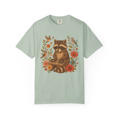 T-shirt with vintage raccoon DJ design surrounded by coral flowers, yellow blooms, and songbirds