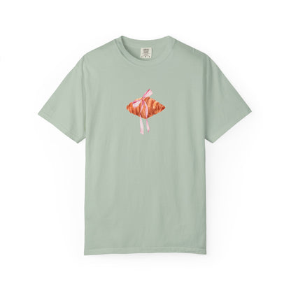 T-shirt with watercolor croissant design featuring golden brown pastry with pink ribbon bow