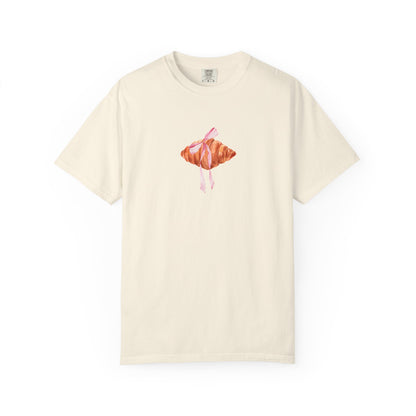 T-shirt with watercolor croissant design featuring golden brown pastry with pink ribbon bow