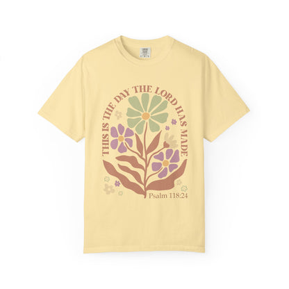 T-shirt with 'This is the Day' text, Psalm 118:24 verse, and floral design with protective hands in sage green, pink, and terracotta colors