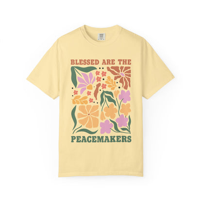 T-shirt with 'Blessed Are The Peacemakers' text surrounded by colorful floral design in pink, coral, yellow and green
