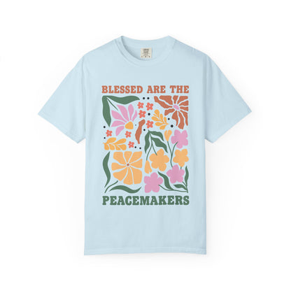 T-shirt with 'Blessed Are The Peacemakers' text surrounded by colorful floral design in pink, coral, yellow and green