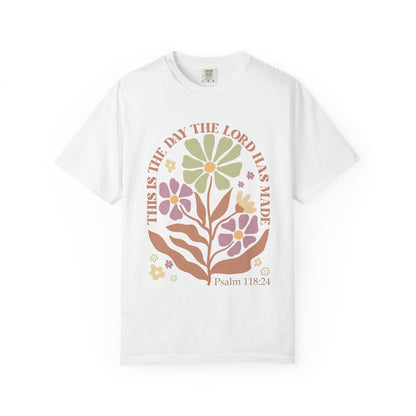 T-shirt with 'This is the Day' text, Psalm 118:24 verse, and floral design with protective hands in sage green, pink, and terracotta colors