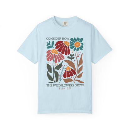T-shirt with Luke 12:27 Bible verse and colorful wildflowers in red, pink, teal, and brown tones