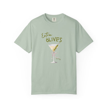 T-shirt design with martini glass, green olives, and pink bow saying Extra Olives Please