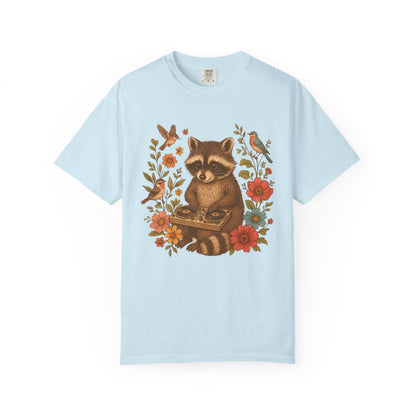 T-shirt with vintage raccoon DJ design surrounded by coral flowers, yellow blooms, and songbirds