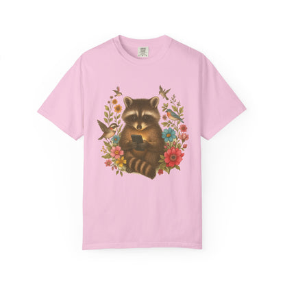 T-shirt design showing raccoon holding phone surrounded by colorful wildflowers and birds