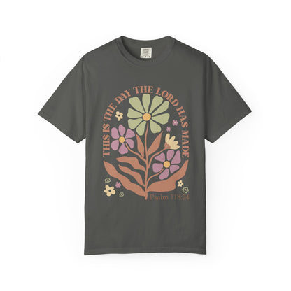 T-shirt with 'This is the Day' text, Psalm 118:24 verse, and floral design with protective hands in sage green, pink, and terracotta colors